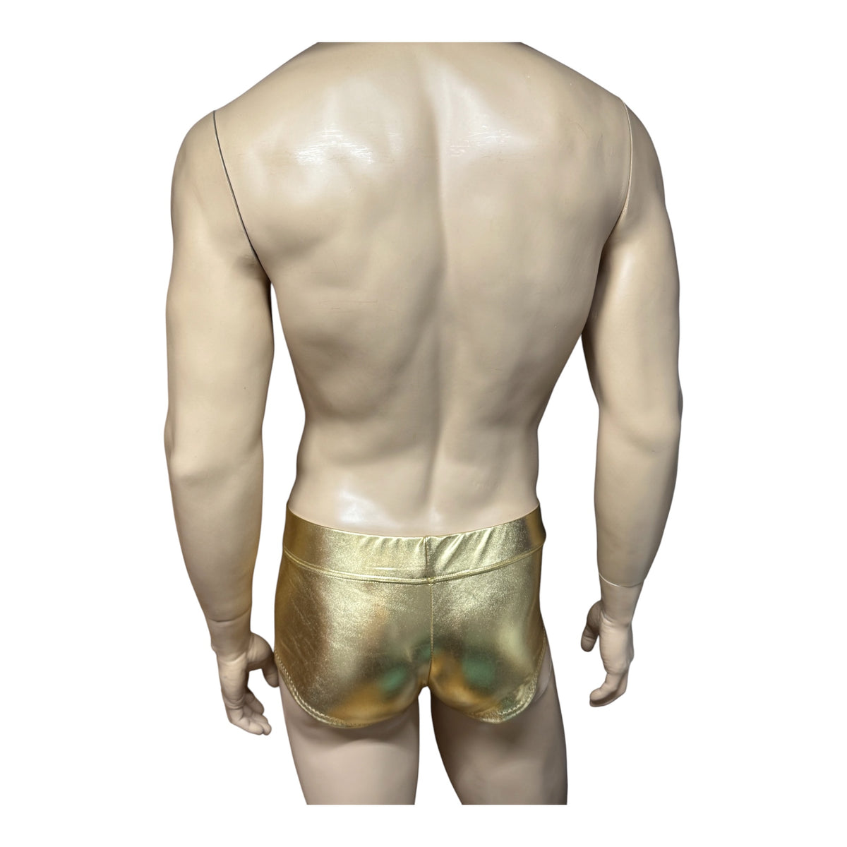 Rear view of men's metallic gold booty shorts on a mannequin, showing the wide waistband and back coverage against white.